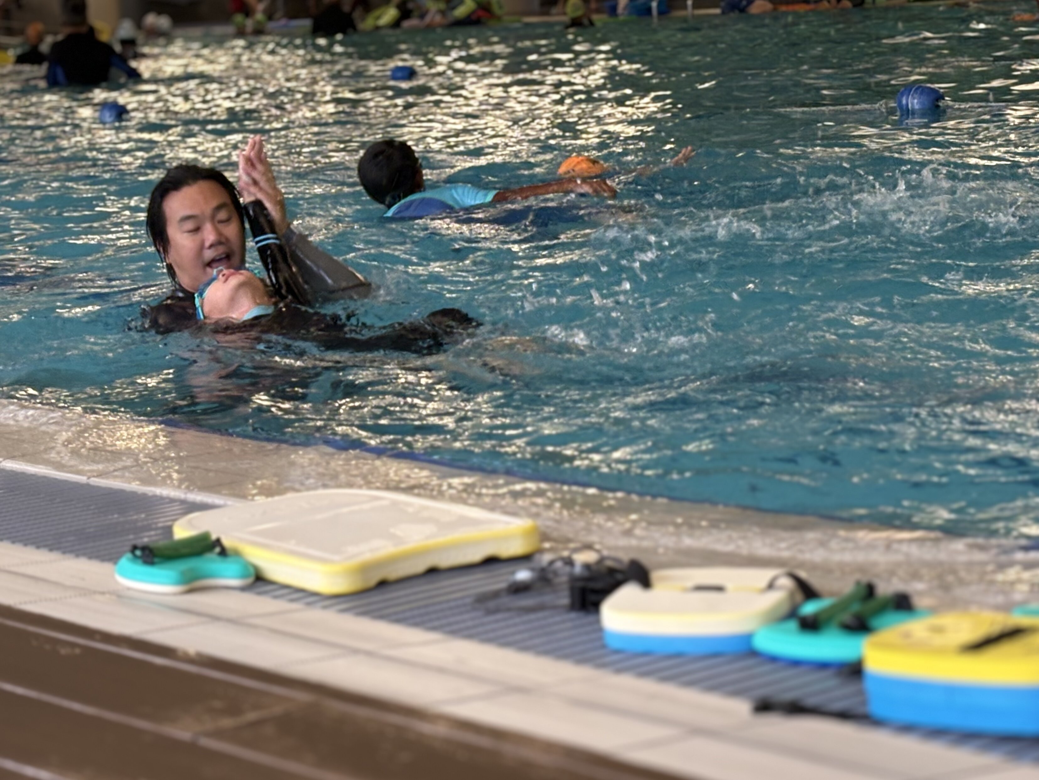 Coach Lee Yucong correcting student backstroke technique at Bukit Canberra Swimming Complex